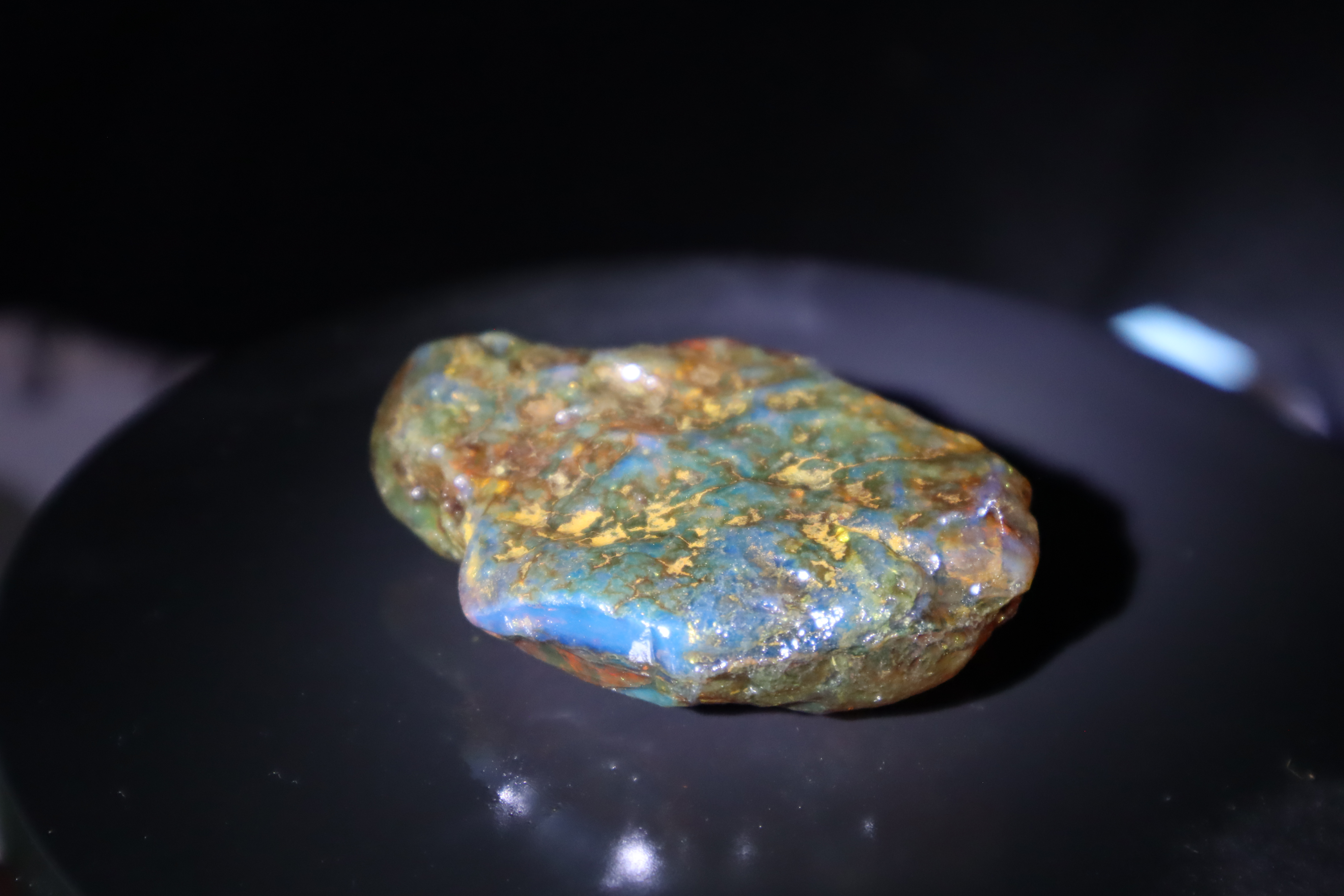 Blue amber rough stone on dark surface